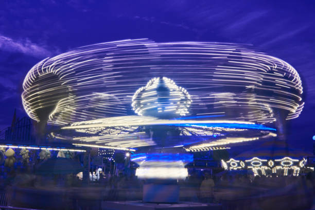 istock Spinning white, blue and yellow carnival or fair ride 1491320756