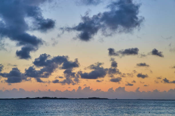 istock Sunset on the ocean with small island and tiny dark clouds 1491321378