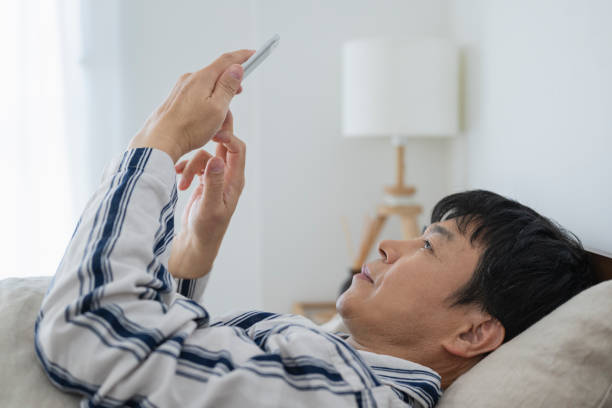 istock Middle-aged man looking at his smartphone in bed in the morning 1491321932