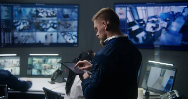 istock Male officer controls security cameras uses tablet 1491322429