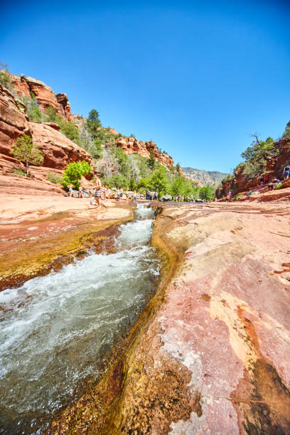 istock Tourists in red rock canyon with rapids river water running slide 1491322630