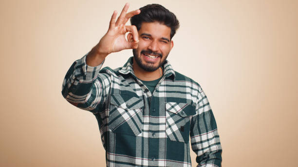 istock Man looking approvingly, showing ok approve feedback gesture like sign positive something good 1491322941