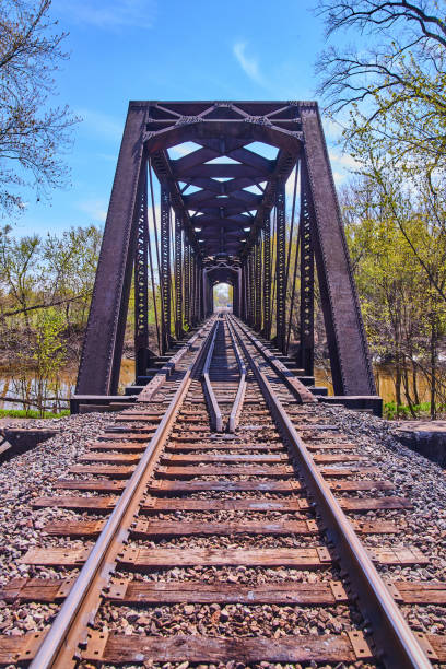 istock Vertical of train tracks with steel bridge over river 1491323996