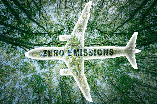 Icon of a commercial airplane with the words 'zero emissions' and a lush forest in the background. Suitable for concepts as Zero emissions, SAF or Sustainable Aviation Fuel, Circular economy and netCO2 emissions.