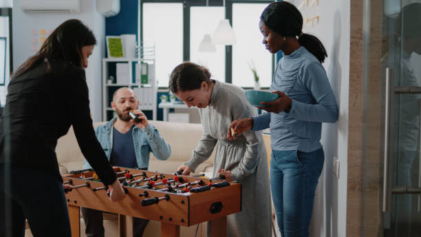 istock Multi ethnic coworkers playing game with foosball table 1491324270