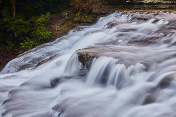 istock Water flowing heavily over cascading waterfall rocks 1491324434