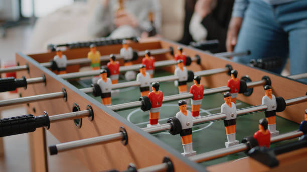 istock Close up of colleagues playing at foosball table after work 1491326184
