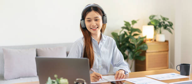 istock Female freelance is reading business data on laptop and writing 1491326702
