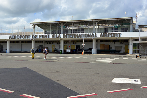 Port Vila, Vanuatu: Bauerfield / Port Vila International Airport (VLI), hub for Vanuatu's flag carrier airline, Air Vanuatu - passengers arrived at the international terminal (air side). Sign in French and English, the official languages.