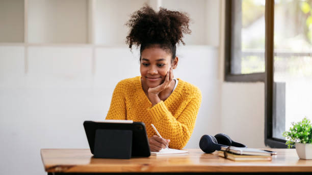 istock African american student woman in sweater watching e-learning to 1491329168