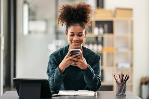 istock African american student woman in sweater using smartphone after 1491329173