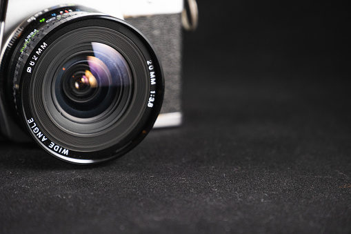 Close up of camera lens and photography equipment on a wooden table.