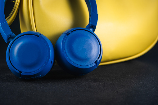 Photographed in a light box, An elegant yellow case and blue wireless earphones