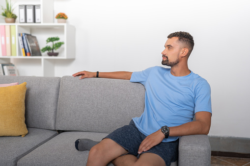 Young man sitting on the sofa in his apartment living room