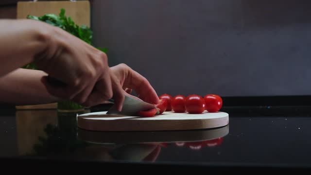 Handheld Slow Motion Shot Of Hands Slicing Cherry Tomatoes