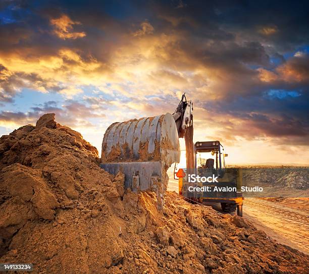 Excavator On The Construction Site Of The Road Against The Setting Sun Stock Photo - Download Image Now