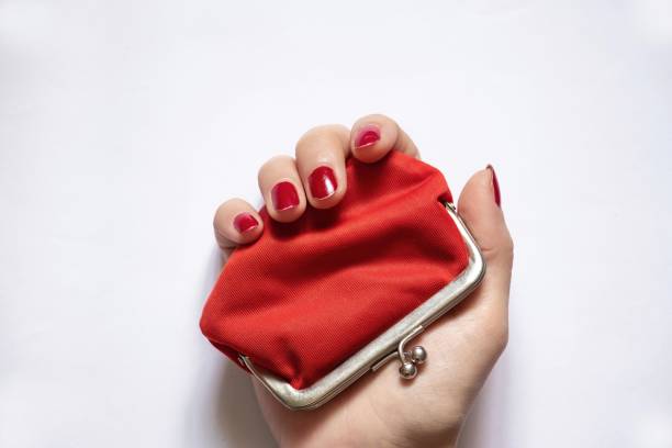 istock red old wallet and female hand on isolated background close-up 1491334801