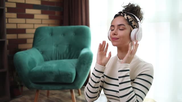 Young woman listening to guided meditation on headphones