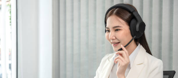 istock Female call center provides information to a customer calling for help, Contact us, Service with a beautiful and friendly voice, Long distance communication, Talk using headphones or headsets 1491335342