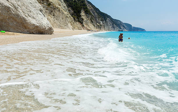 Family on beach Family have the water-based recreation on white beach near azure Ionian sea (Egremni, Lefkada, Greece) egremni beach lefkada island greece stock pictures, royalty-free photos & images
