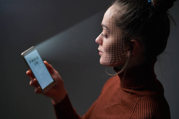 les femmes scannent le visage à l’aide du système de reconnaissance faciale sur le téléphone portable pour l’identification biométrique. futures technologies de haute technologie et face id - id card photos et images de collection