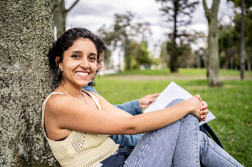 Portrait of a young student studying at public park