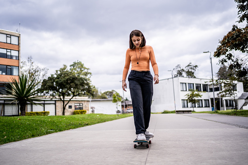 Young woman skateboarding through the city