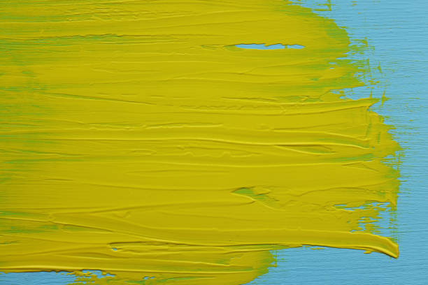 Close up of the artist's hand squeezed from a tube paint on palette. Painter at work