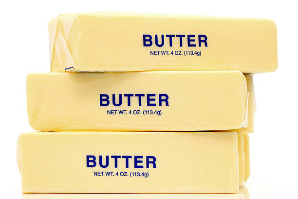 Butter Quarters Traditional wrapped butter sticks on white background butter stock pictures, royalty-free photos & images