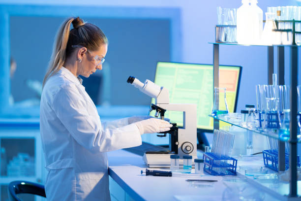 istock Female research scientist is analysing a sample on her microscope in a microbiology lab 1491347823