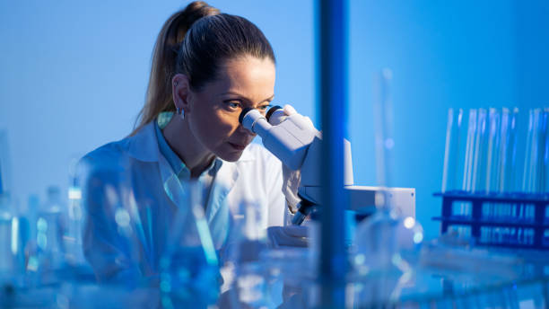 istock Female research scientist is analysing a sample on her microscope in a microbiology lab 1491347853