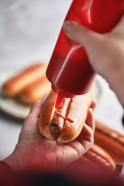 istock Preparing Hot Dog with Mustard and Ketchup 1491348968