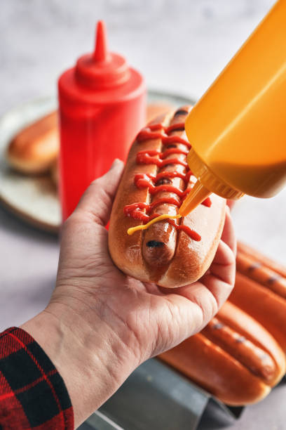 istock Preparing Hot Dog with Mustard and Ketchup 1491348972