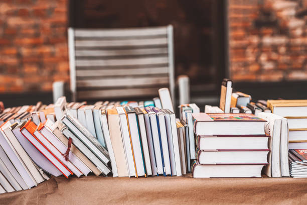 istock Pile of books on table outdoor. Abstract blurred background . Education, school, study, reading literature 1491349955