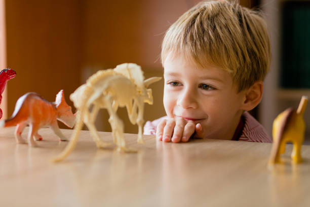 istock Smiling little boy looking at the dinosaur toy 1491350531