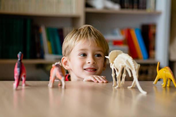 istock Smiling little boy looking at the dinosaur toy 1491350550