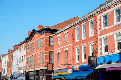 Row of traditional American brick buildings with stores on the ground floor in a old downtown district on a clear autumn day. Portsmouth, NH, USA.