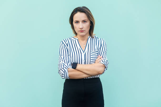 istock Serious woman standing with crossed arms and looking at camera with strict bossy expression. 1491351848