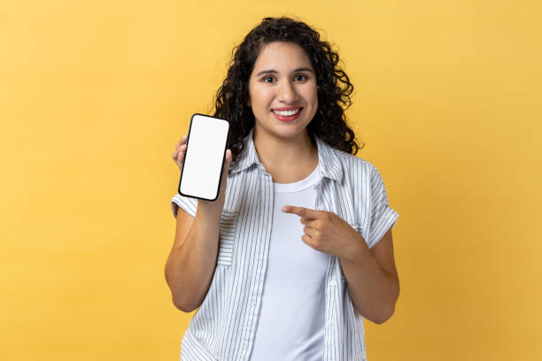 istock Smiling woman holding pointing at cell phone with empty display, copy space for advertisement. 1491352776