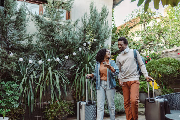 istock Young tourists with suitcases using smart phone 1491355792