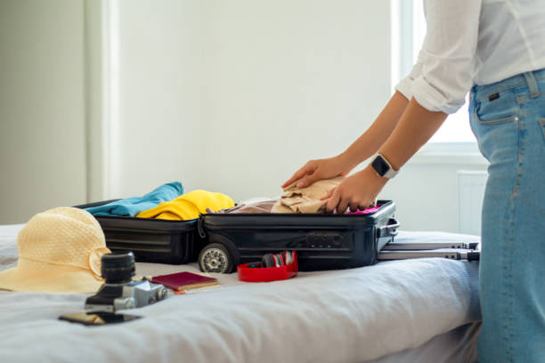 femme préparant sa valise pour les vacances - affaires personnelles photos et images de collection