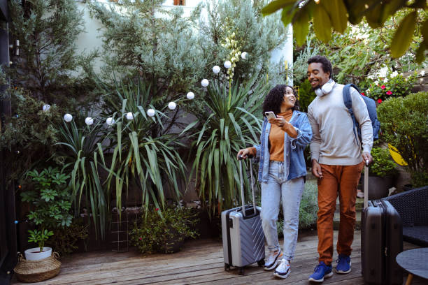 istock Young tourists with suitcases using smart phone 1491356743
