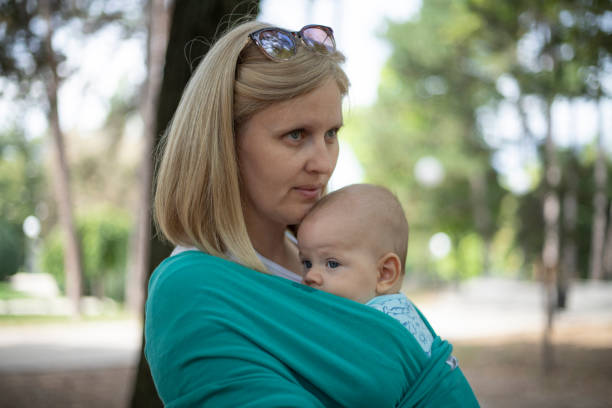 istock Mom carrying a baby in a sling 1491356823