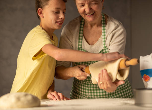 istock boy helps grandma to make pizza dough 1491356852