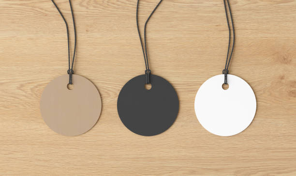 istock White, cardboard, black round tags mockup on wooden background. View directly above 1491362267