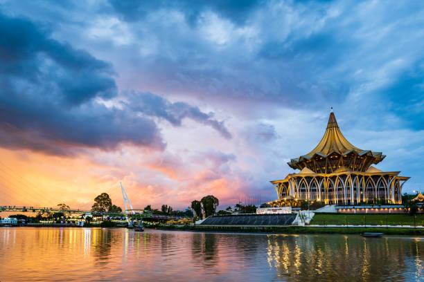 vue du coucher de soleil sur le front de mer de la ville de kuching avec rivière et monuments à sarawak, malaisie - kuching photos et images de collection