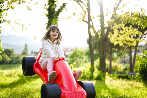 A bright blue and green children's toy car stands on a playground
