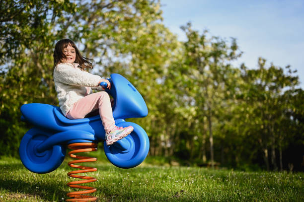 preschool girl having fun outdoors in a playground.