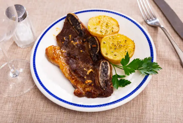 Photo of Grilled beef ribs churrasco with fried potatoes and greens