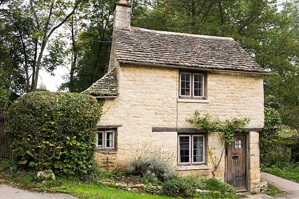 small golden limestone cottage in the village of bilbury in the cotswalds, gloucestershire, england